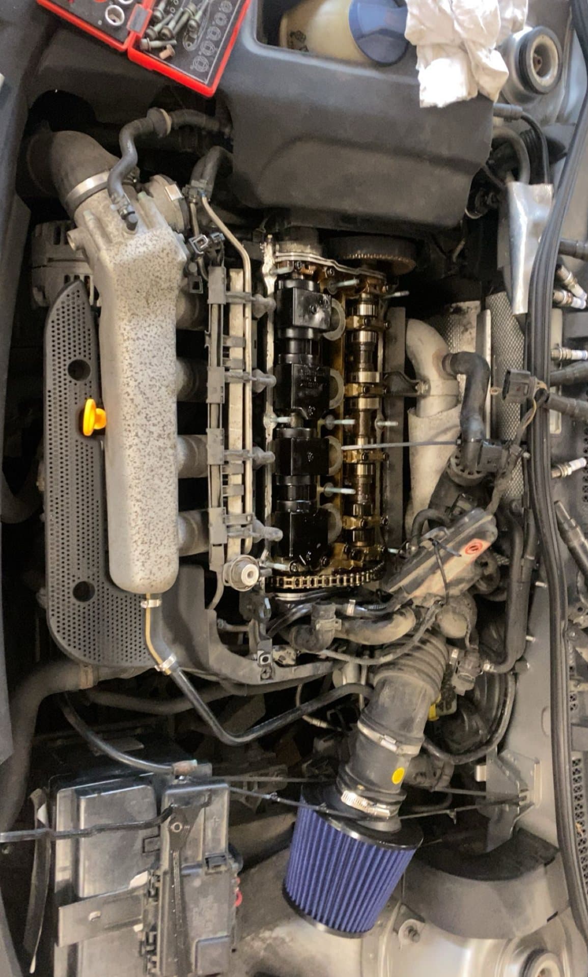 Motorrummet på en Audi TT 1.8T med ventilkåpan av och kamaxlarna synliga, ett blått konfilter på insuget.